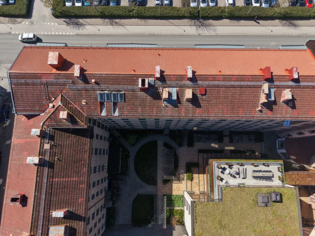 Drönarbild av större fastighet med tegeltak inför taktvätt för BRF och flerbostadshus